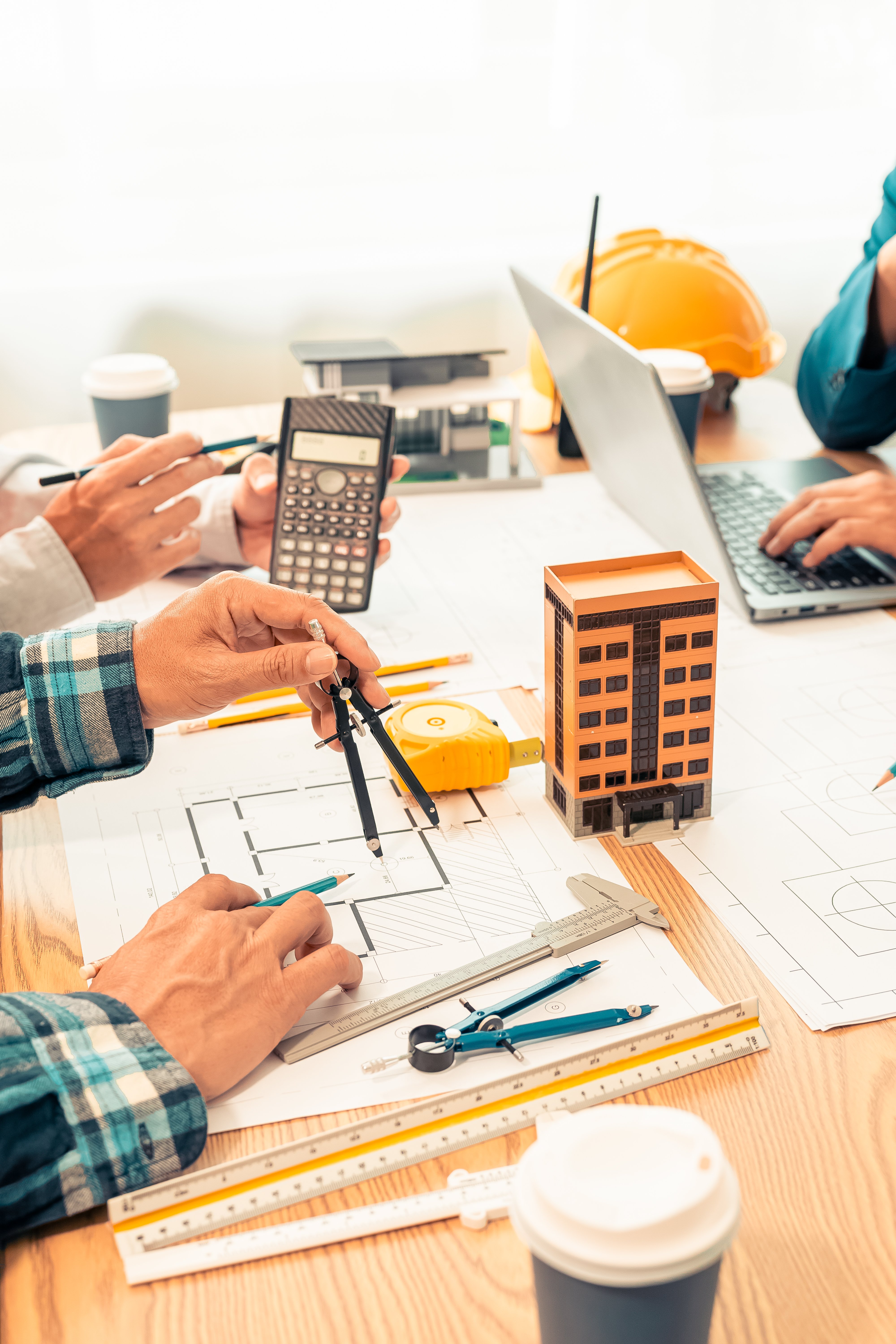 Group of architectural engineers working together and planning building structure with blueprint and tools